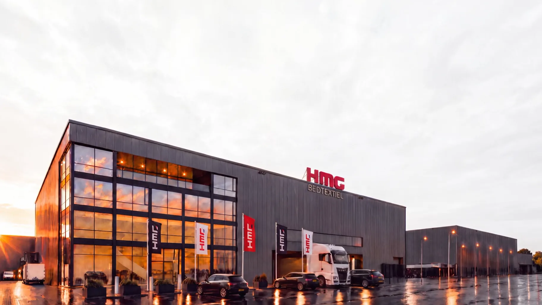 De productiefaciliteit van HMG Bedtextiel bij zonsondergang